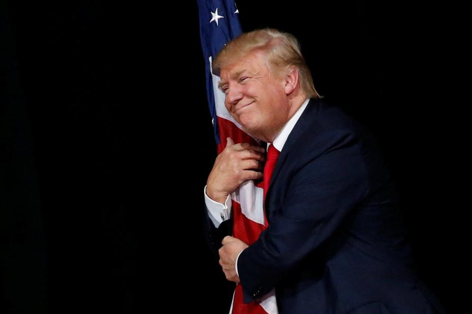 The future is orange: Republican U.S. presidential nominee Donald Trump hugs a U.S. flag (Reuters)