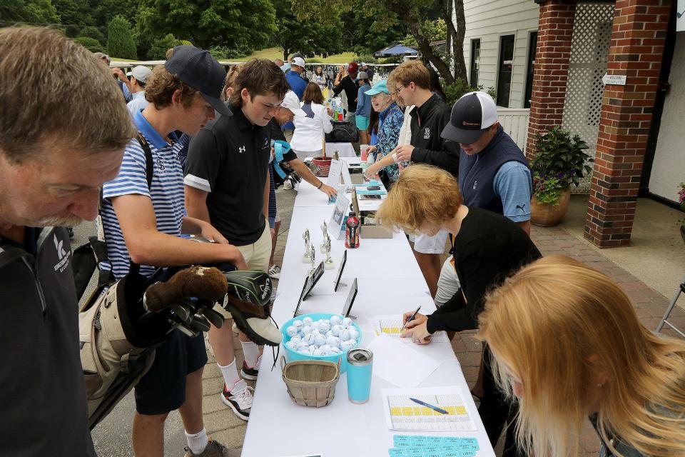 Golfers check in, get information and buy raffle tickets for the Owen Bingham Memorial Golf Tournament on June 22.