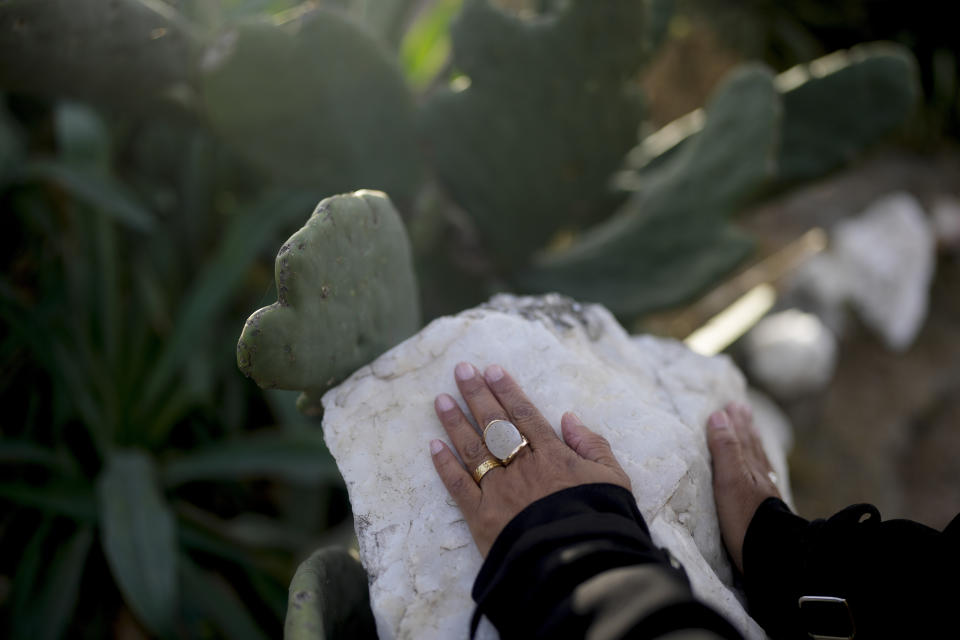 Brazilian Neiva Santos touches a stone inside the Pueblo Encanto spiritual theme park in Capilla del Monte, Argentina, Wednesday, July 19, 2023. In the pope’s homeland of Argentina, Catholics have been renouncing the faith and joining the growing ranks of the religiously unaffiliated. Commonly known as the “nones,” they describe themselves as atheists, agnostics, spiritual but not religious, or simply: “nothing in particular.” (AP Photo/Natacha Pisarenko)