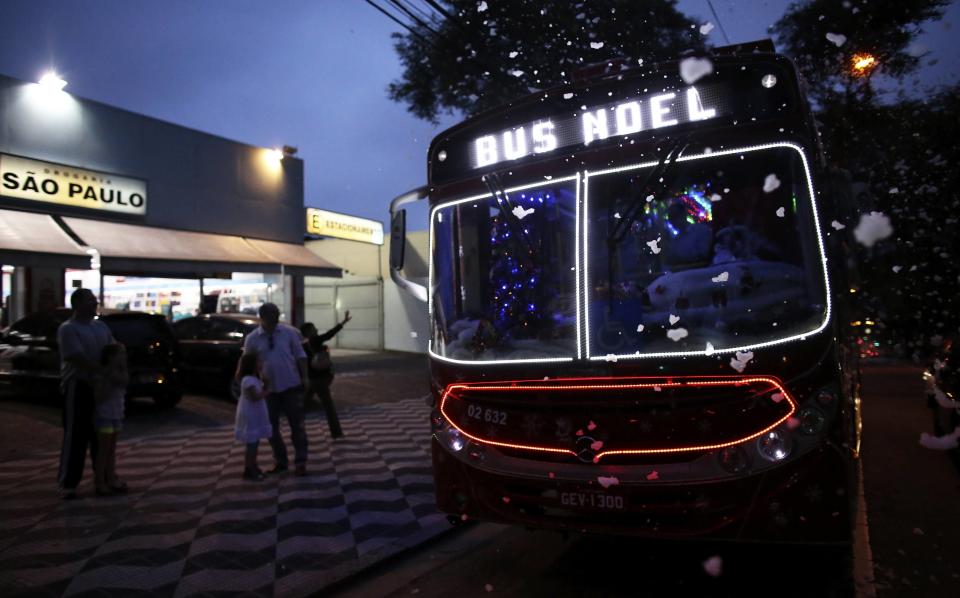 Bus driver Edilson, also known as "Fumassa", greets people as he wears a Santa Claus outfit inside an urban bus decorated with Christmas motives in Santo Andre