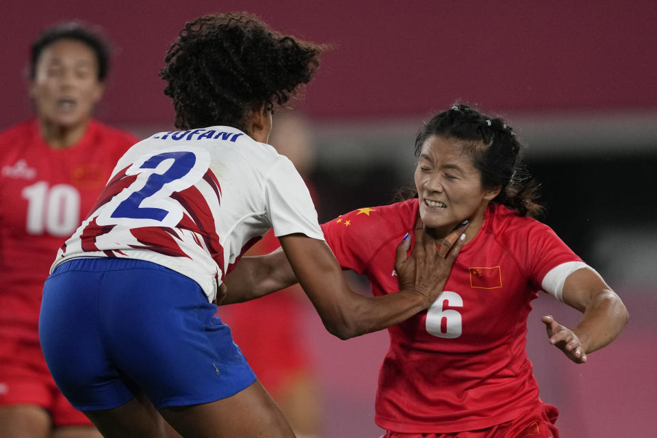 France's Anne-Cecile Ciofani, left, grapples with China's Wang Wanyu, in their women's rugby sevens quarterfinal match at the 2020 Summer Olympics, Friday, July 30, 2021 in Tokyo, Japan. (AP Photo/Shuji Kajiyama)