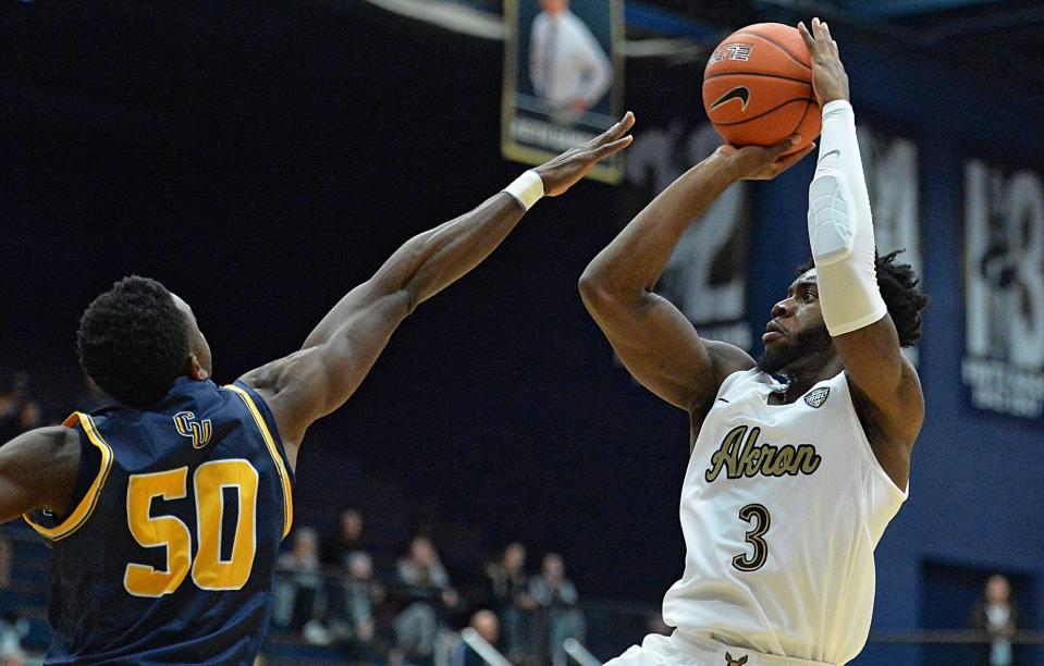 Akron's Daniel Utomi shoots a second-half 3 over Cedarville's Robert Okoro (50) at Rhodes Arena, Tuesday, Nov. 6, 2018.