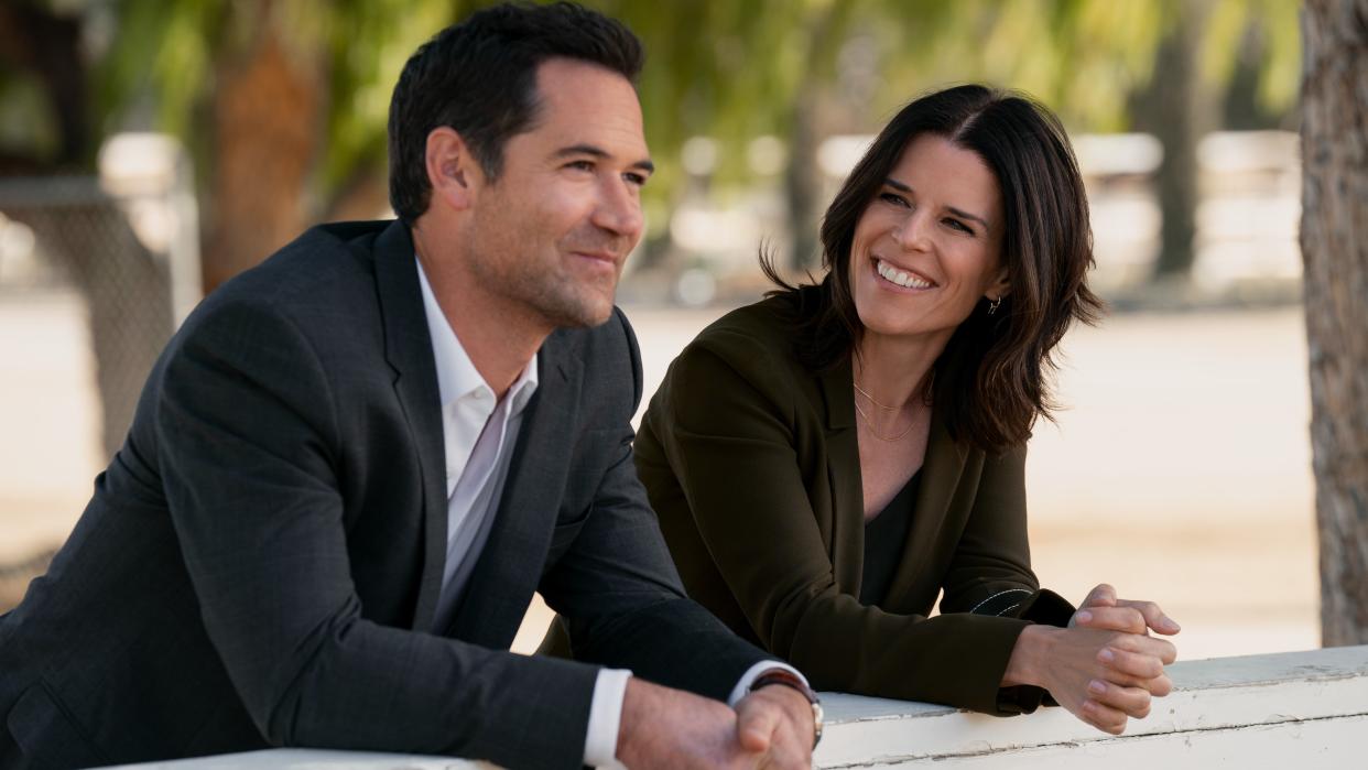  Manuel Garcia-Rulfo and Neve Campbell as Mickey and Maggie smiling as members of The Lincoln Lawyer season 2 cast 