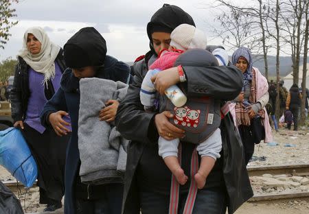 A migrant reacts after she crossed the border from Greece to Gevgelija, Macedonia November 22, 2015. REUTERS/Ognen Teofilovski