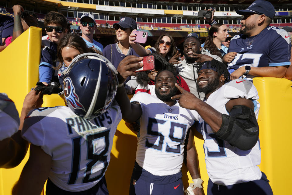 Tennessee Titans wide receiver Kyle Philips (18) defensive tackle Sam Okuayinonu (59) and tight end Chigoziem Okonkwo (85) celebrate with fans after an NFL football game against the Washington Commanders, Sunday, Oct. 9, 2022, in Landover, Md. Tennessee won 21-17. (AP Photo/Alex Brandon)