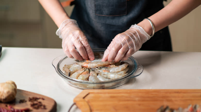 hands peeling shrimp