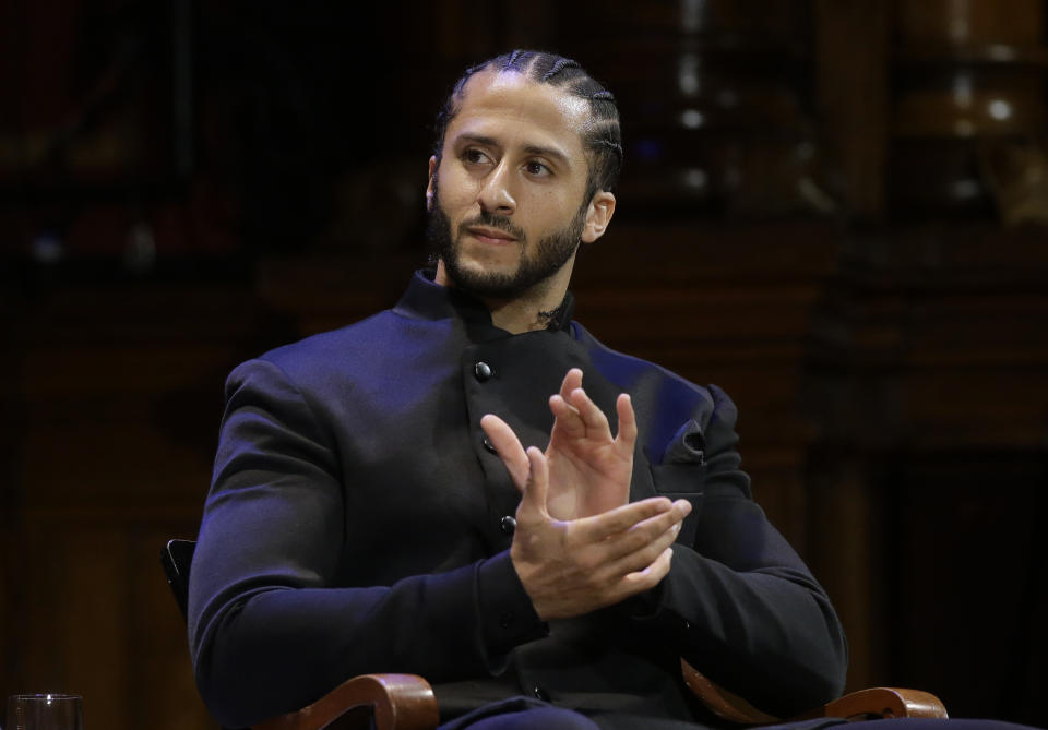 FILE - NFL football quarterback Colin Kaepernick applauds during W.E.B. Du Bois Medal ceremonies at Harvard University in Cambridge, Mass. on Oct. 11, 2018. Kaepernick has been condemned by President Donald Trump and others on the right and had not played an NFL game since 2016, when he began kneeling during the National Anthem to protest “a country that oppresses black people and people of color." But he has appeared in Nike advertisements, been honored by the ACLU and Amnesty International among other organizations and reached an agreement with the Walt Disney Co. for a docuseries about this life. (AP Photo/Steven Senne, File)