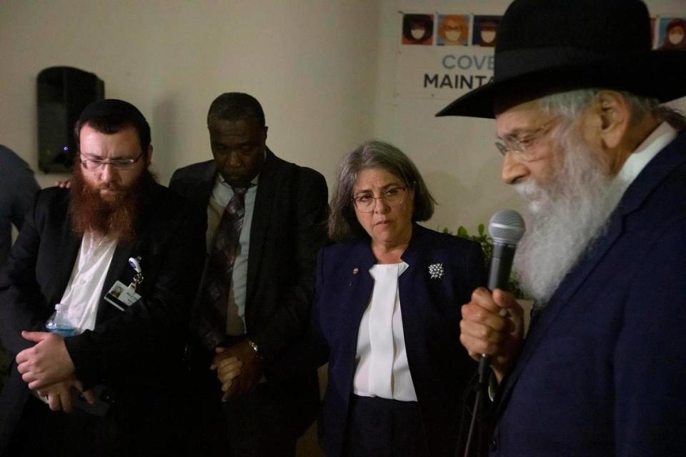 Rabbi Sholom Lipskar, spiritual leader of the Shul of Bal Harbour, prays during the search-and-rescue operation after the partial collapse of the Champlain Towers South in Surfside on Thursday night June 24th., 2021. At left are Rabbi Mendy Levy, Chabad Chaplaincy Network Chaplain -- Mount Sinai Medical Center and Miami-Dade Mayor Daniella Levine Cava.