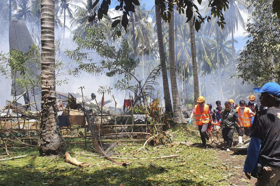 THIS CORRECTS THE NAME OF THE PROVINCE TO SULU, INSTEAD OF JOLO - In this photo released by the Joint Task Force - Sulu, rescuers carry a body from the site where a Philippine military C-130 plane crashed in Patikul town, Sulu province, southern Philippines on Sunday, July 4, 2021. The Philippine air force C-130 aircraft carrying troops crashed in a southern province after missing the runway Sunday, killing more than a dozen military personnel while at least 40 were rescued from the burning wreckage, officials said. (Joint Task Force-Sulu via AP)