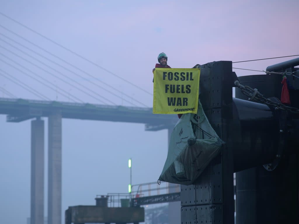 Greenpeace climbers hang off a berth at a UK port (Â© Fionn Guilfoyle / Greenpeace)