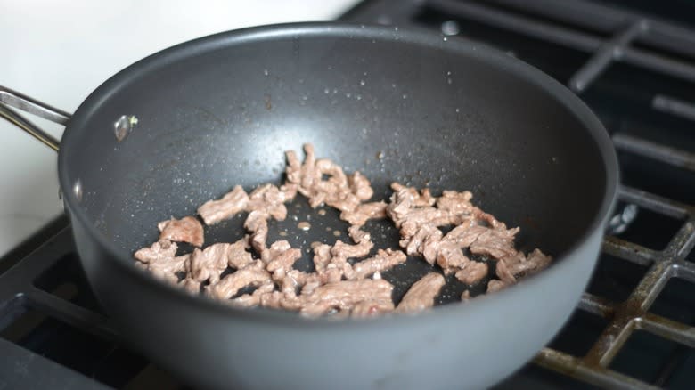 steak strips cooking in pan