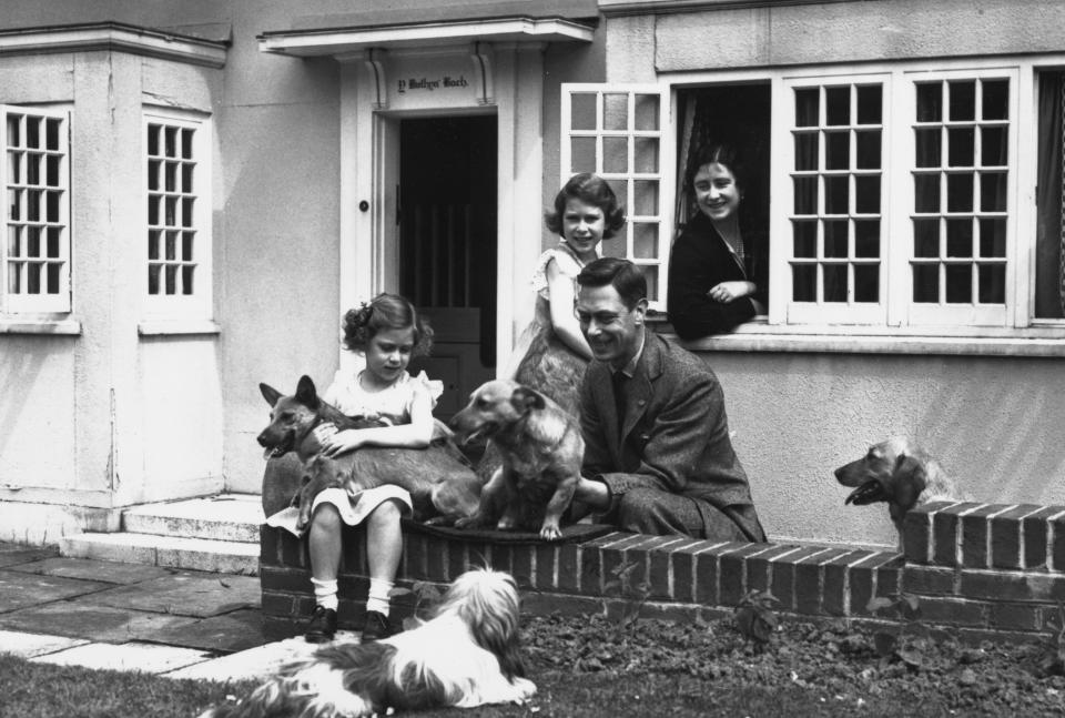 (From left) Princess Margaret, Princess Elizabeth, King George VI, and Queen Elizabeth (the Queen Mother) in front of a miniature cottage on the Windsor Castle grounds given to the children by the people of Wales in 1932