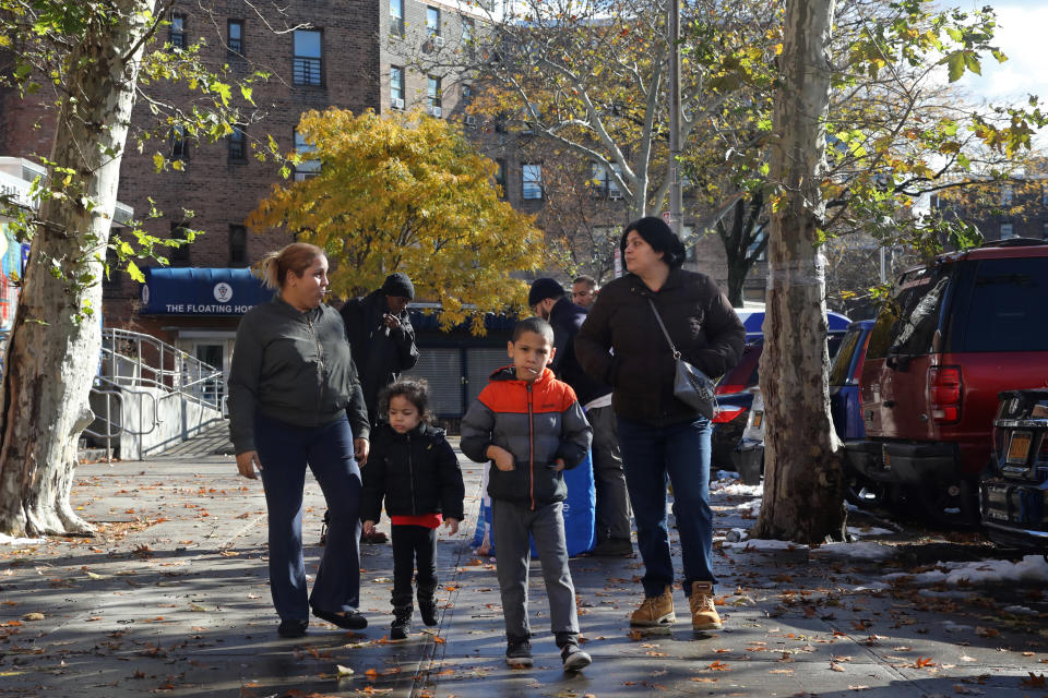 Residents of the Queensbridge Houses walk in the neighborhood, Friday, Nov. 16, 2018, in New York. Some of those who live in the public housing complex in Long Island City are cynical whether any of the thousands of jobs that are being touted by Amazon would come to them. Others are hopeful that they'll benefit, too. (AP Photo/Mark Lennihan)