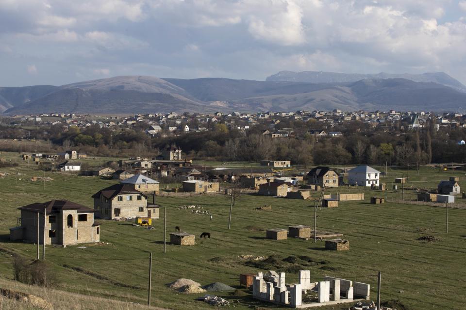 In this photo taken Thursday, March 27, 2014 Crimea's Tatars recent and long-standing squatter settlements are placed near the village of Dobroye, foreground, not far from Simferopol, Crimea. On Saturday the Crimean Tatar Qurultay, a religious congress will determine whether the Tatars will accept Russian citizenship and the political system that comes with it, or remain Ukrainian citizens on Russian soil. (AP Photo/Pavel Golovkin)