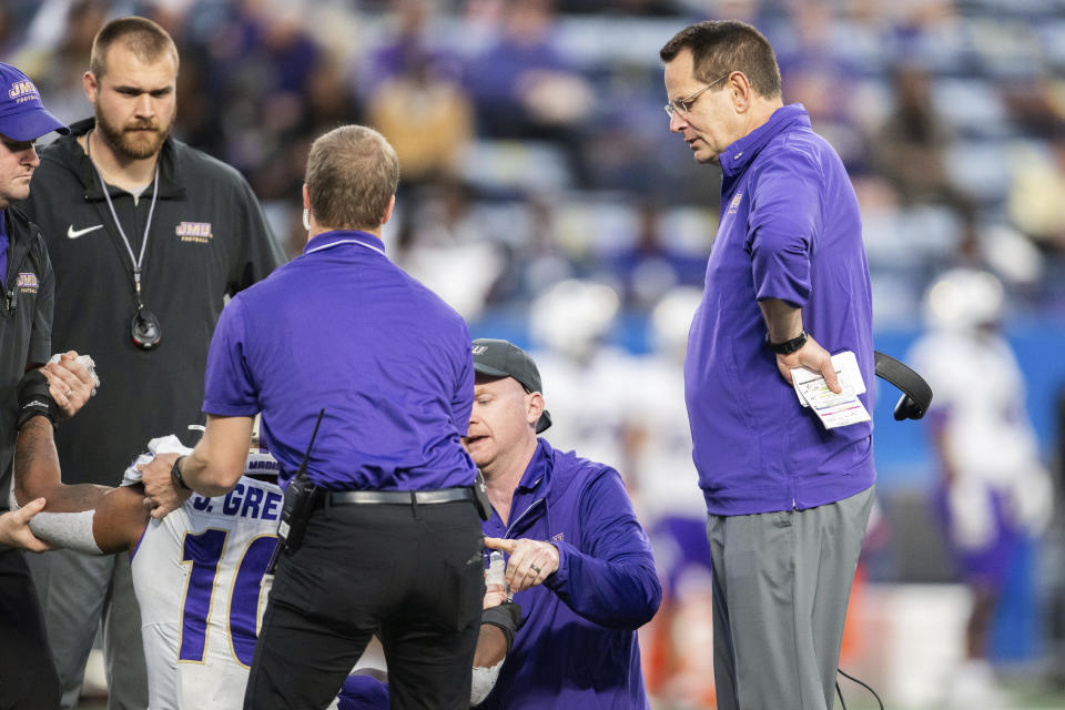 James Madison head coach Curt Cignetti, right, and training staff check defensive lineman Jalen Green (10) in the second half of an NCAA college football game against Georgia State, Saturday, Nov. 4 2023, in Atlanta. (AP Photo/Hakim Wright Sr.)