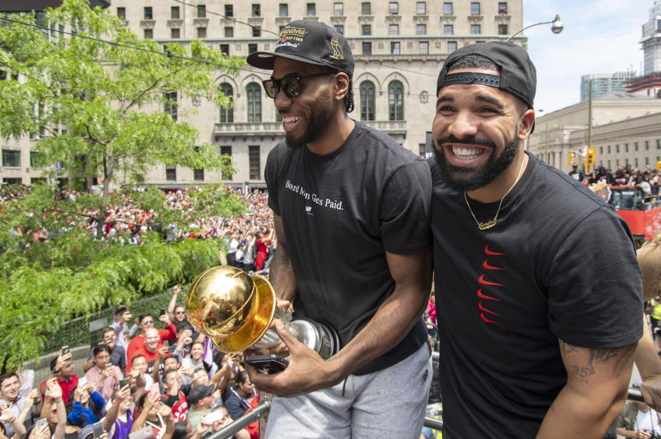 Toronto Raptors' Kawhi Leonard holds his MVP trophy with rapper/producer Drake as they celebrate during the team's NBA basketball championship parade in Toronto, Monday, June 17, 2019. (Frank Gunn/The Canadian Press via AP)