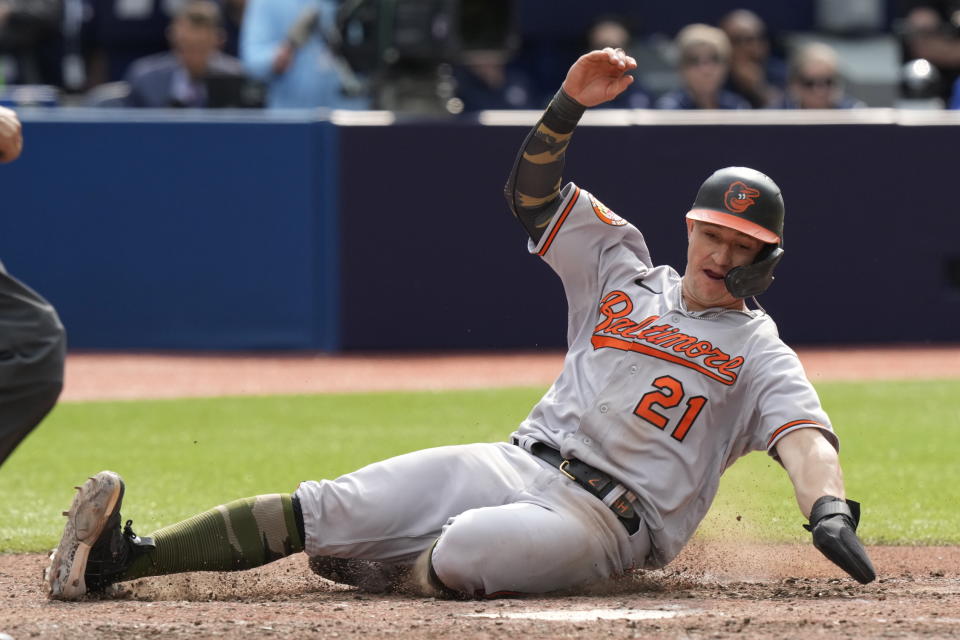 Baltimore Orioles left fielder Austin Hays (21) slides into home plate to score his team's sixth run against the Toronto Blue Jays during the eleventh inning of a baseball game in Toronto, Sunday, May 21, 2023. (Frank Gunn/The Canadian Press via AP)