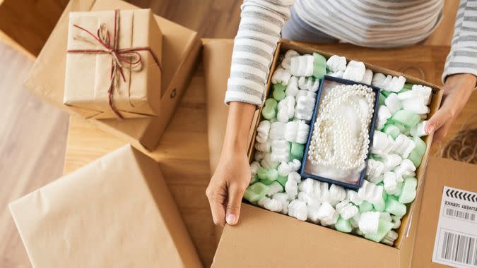 Woman opening many parcels she received, view from above, fees, America, money, payment, avoid fees, bills, debt