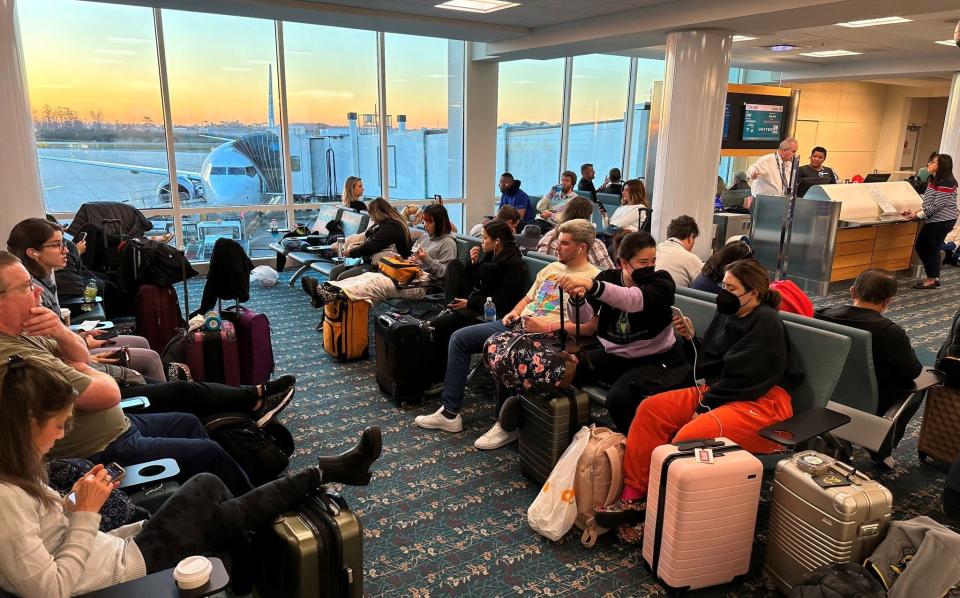 Stranded passengers wait at the Orlando International Airport as flights were grounded across US FAA - Lou Mongello via REUTERS