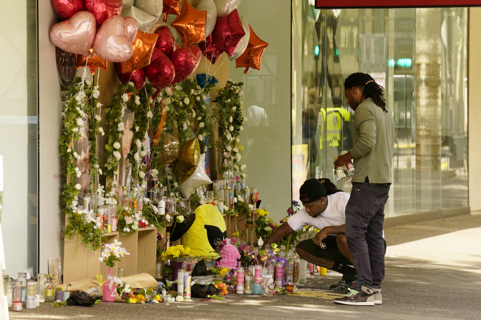 Mourners visit a memorial to victims of a recent mass shooting in Sacramento, Calif., Friday, April 8, 2022. The April 3 shooting, which left six dead and 12 wounded, occurred near the state Capitol, an area that in recent years has been rattled by rising crime, protests and the economic drubbing of the pandemic. (AP Photo/Rich Pedroncelli)