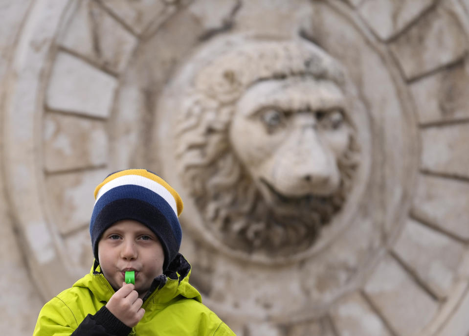 A boy blows a whistle during a protest for clean air in Belgrade, Serbia, Sunday, Nov. 28, 2021. Several thousand people have rallied in Belgrade for another environmental protest, a day after demonstrators blocked bridges and roads on several locations in Serbia, and scuffled with riot police who deployed to stop them. (AP Photo/Darko Vojinovic)