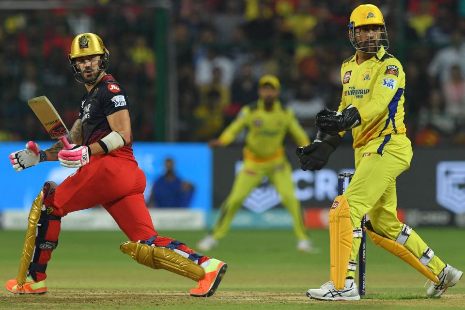 Royal Challengers Bangalore's Faf du Plessis (L) and Chennai Super Kings' Mahendra Singh Dhoni (R) gesture during an IPL match between Royal Challengers Bangalore and Chennai Super Kings at the M Chinnaswamy Stadium in Bengaluru on April 17, 2023.