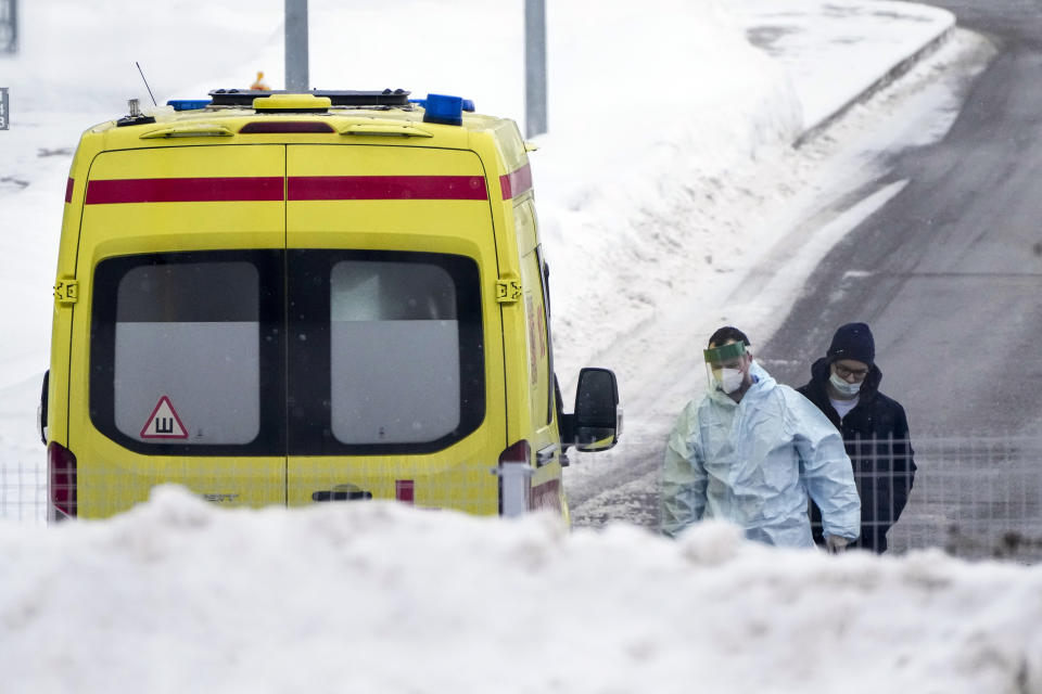 A patient suspected of having coronavirus walks follows a medical worker to a hospital in Kommunarka, outside Moscow, Russia, Sunday, Jan. 23, 2022. Daily new coronavirus infections in Russia have reached an all-time high and authorities are blaming the highly contagious omicron variant, which they expect to soon dominate the country's outbreak. (AP Photo/Alexander Zemlianichenko)