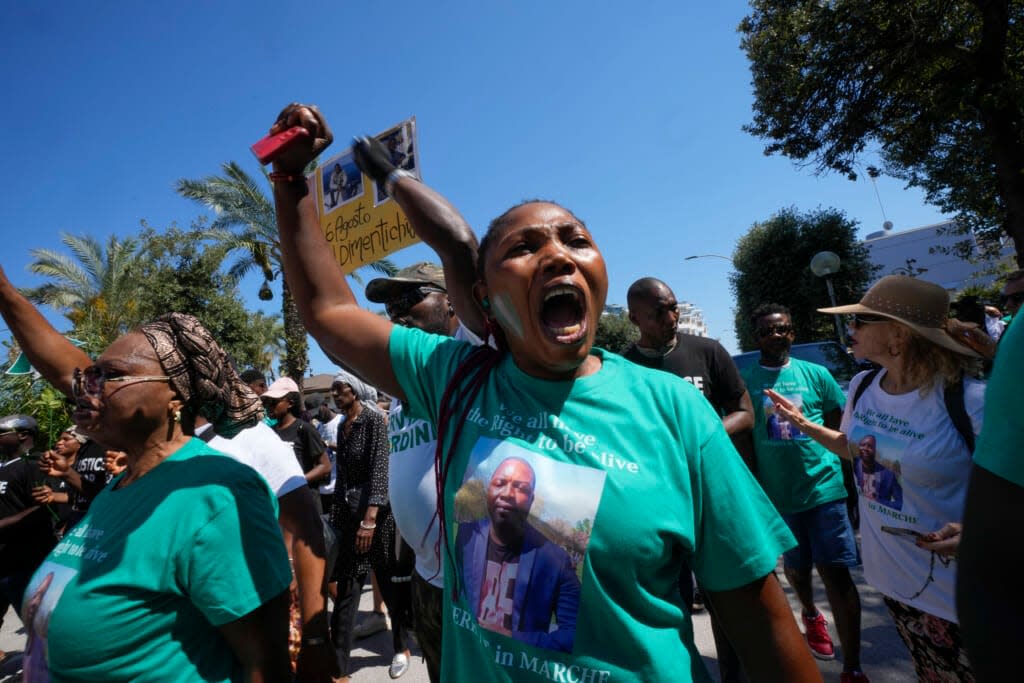 A woman wears a t-shirt with the picture of Nigerian street vendor Alika Ogorchukwu and a writing reading: We all have the right to be alive, during a protest in Civitanova Marche, Italy, Saturday, Aug. 6, 2022.(AP Photo/Antonio Calanni)