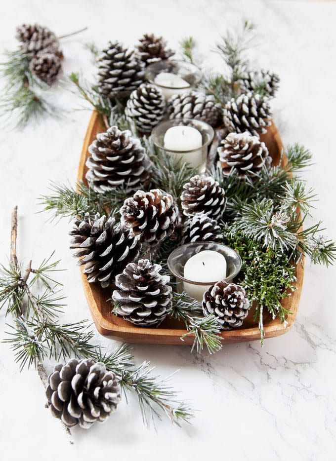 snow covered pine cones and branches centerpiece with candles