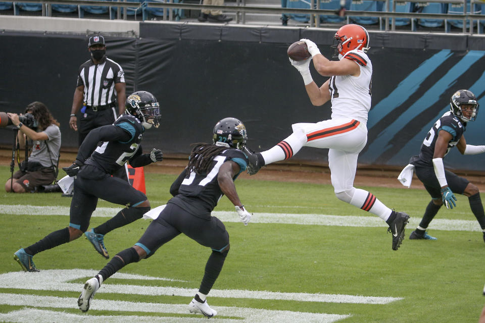 Cleveland Browns tight end Austin Hooper, right, catches a touchdown pass in front of Jacksonville Jaguars safety Jarrod Wilson, left, and cornerback Tre Herndon, center, during the first half of an NFL football game, Sunday, Nov. 29, 2020, in Jacksonville, Fla. (AP Photo/Stephen B. Morton)