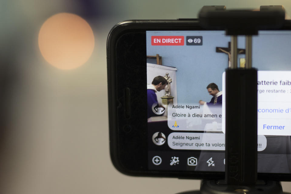 A livestream viewer comments "glory be to god, amen" during a closed door Sunday mass livestream at the St. Vincent de Paul church in Marseille, southern France, Sunday, March 22, 2020. As mass gatherings are forbidden due to measures to prevent the spread of COVID- 19, priests are using technology to reach worshippers forced to stay at home. For most people, the new coronavirus causes only mild or moderate symptoms. (AP Photo/Daniel Cole)