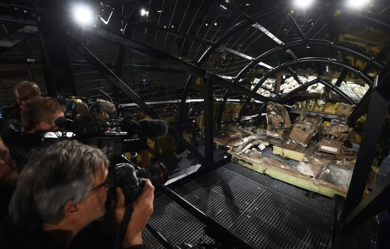 Journalists take images of the wrecked cockpit of the Malaysia Airlines flight MH17 during a presentation of the final report on the cause of its crash, at the Gilze Rijen airbase October 13, 2015