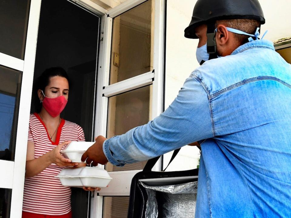 A delivery person hands an order to a customer.