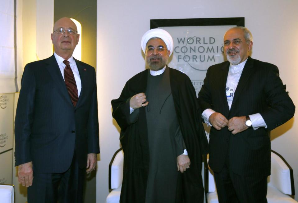 Iranian President Hassan Rouhani, center, poses with Iranian Foreign Minister Mohammad Javad Zarif, right, and WEF founder Klaus Schwab, left, during a meeting at the annual meeting of the World Economic Forum (WEF) 2014 in Davos Wednesday Jan. 22, 2014. (AP Photo/Denis Balibouse,Pool))