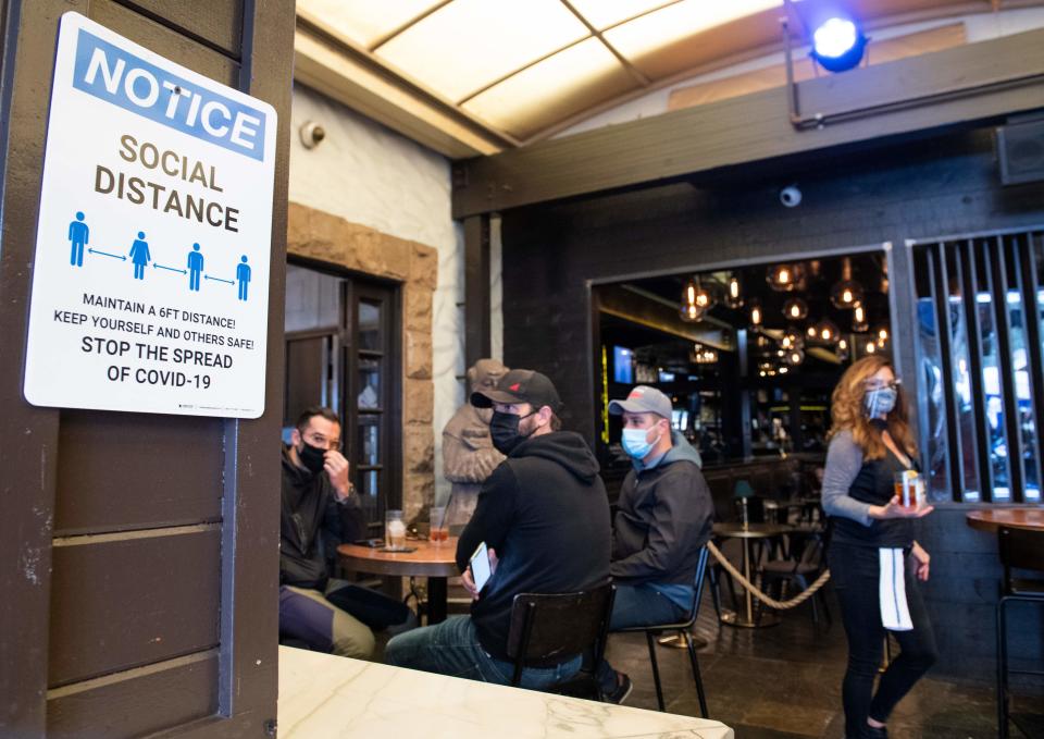 A notice inviting patrons to social distance is seen in the outdoor seating area of The Abbey Food & Bar on January 29, 2021 in West Hollywood, California. (Valerie Macon/AFP via Getty Images)