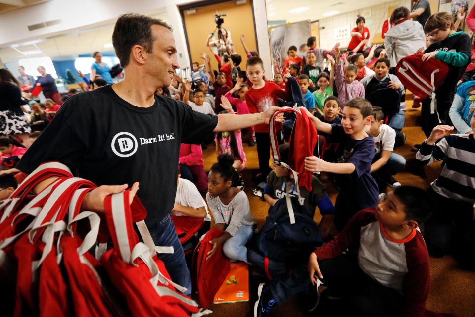 In a Standard-Times file photo, Jeff Glassman of Darn It! Inc. hands out backpacks to Gomes School students, donated by State Bags who donate a bag for every backpack purchased on their website to schools around the country.