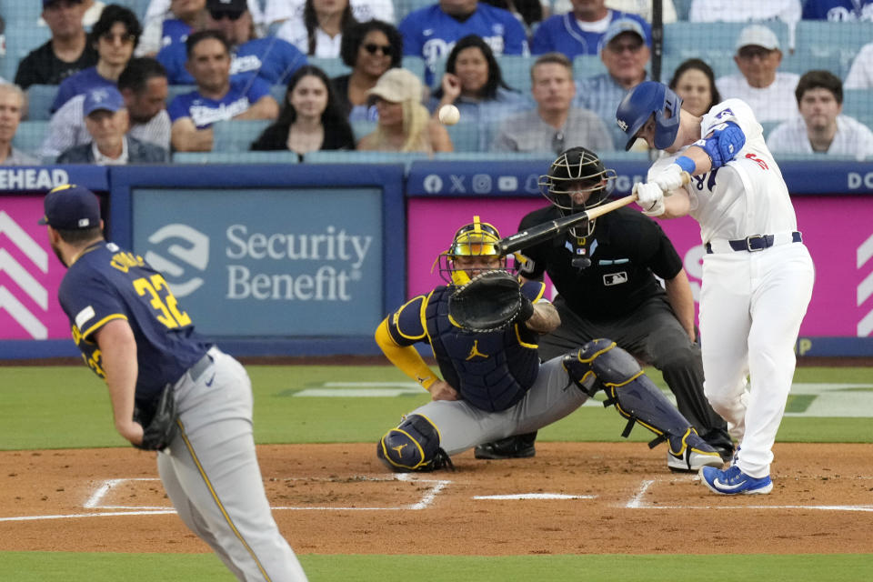 Los Angeles Dodgers' Will Smith, right, hits a solo home run as Milwaukee Brewers starting pitcher Aaron Civale, left, and catcher William Contreras, second from left, watch along with home plate umpire Brian Walsh during the first inning of a baseball game Friday, July 5, 2024, in Los Angeles. (AP Photo/Mark J. Terrill)