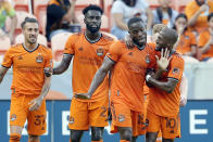 Houston Dynamo's Maximiliano Urruti (37) and Derrick Jones (21) look on as Maynor Figueroa (15) and Fafa Picault (10) celebrate a goal by Picault against the Portland Timbers during the first half of an MLS soccer match Wednesday, June 23, 2021, in Houston. (AP Photo/Michael Wyke)