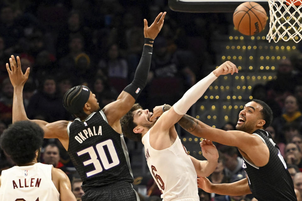 Sacramento Kings forwards Trey Lyles, right, and KZ Okpala, second from left, fight for the rebound against Cleveland Cavaliers forward Cedi Osman, second from right, during the first half of an NBA basketball game, Friday, Dec. 9, 2022, in Cleveland. (AP Photo/Nick Cammett)