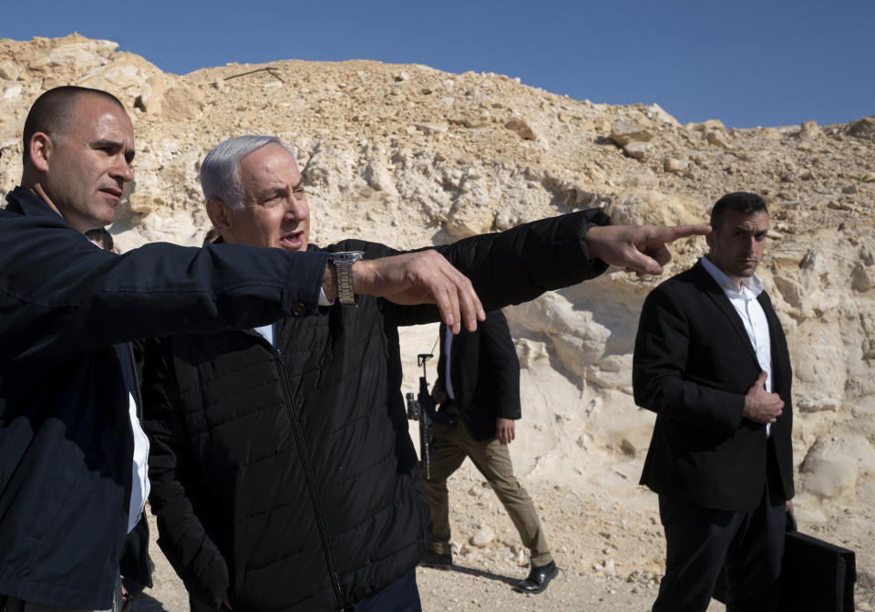 Israel's Prime Minister Benjamin Netanyahu, accompanied by aides and security personnel, visits the southern border with Egypt at Nitzana, Israel, in the Negev Desert, Thursday, March 7, 2019. (Jim Hollander/Pool via AP)