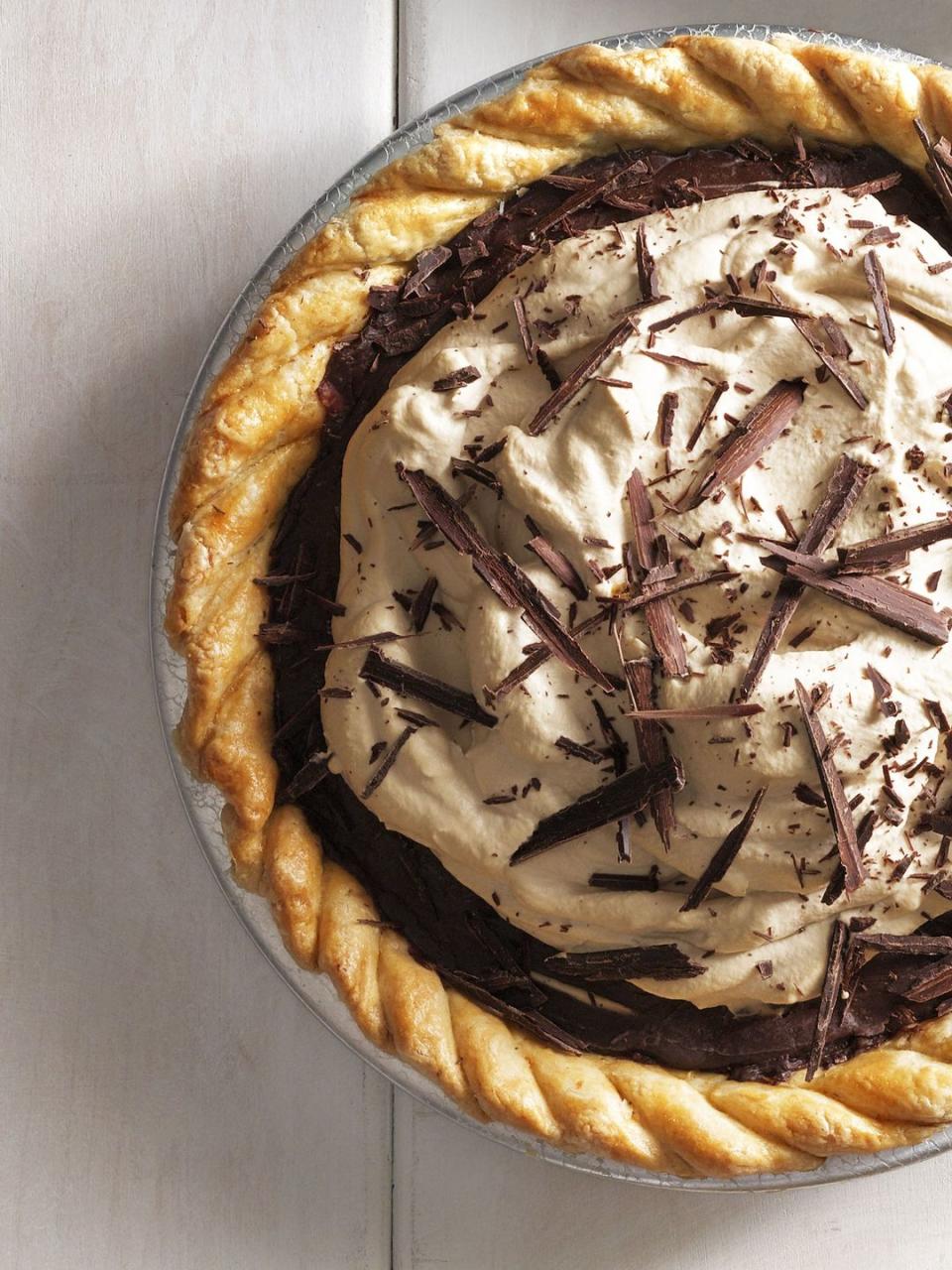 decadent chocolate espresso pie in a metal pie tin with whipped cream and chocolate shavings on top