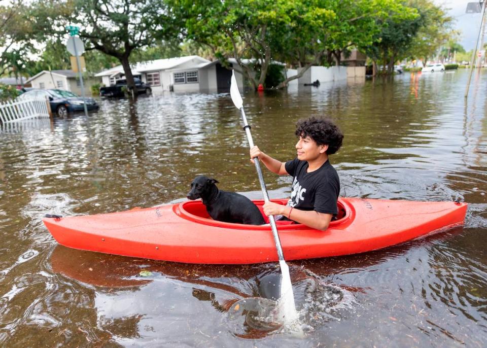 Stranahan High School student, Erick Martinez, 16, and his dog, Estrella, ride a kayak down a flooded street in his Edgewood neighborhood on Thursday, April 13, 2023, in Fort Lauderdale, Fla. A torrential downpour severely flooded streets partially submerging houses and cars across South Florida.