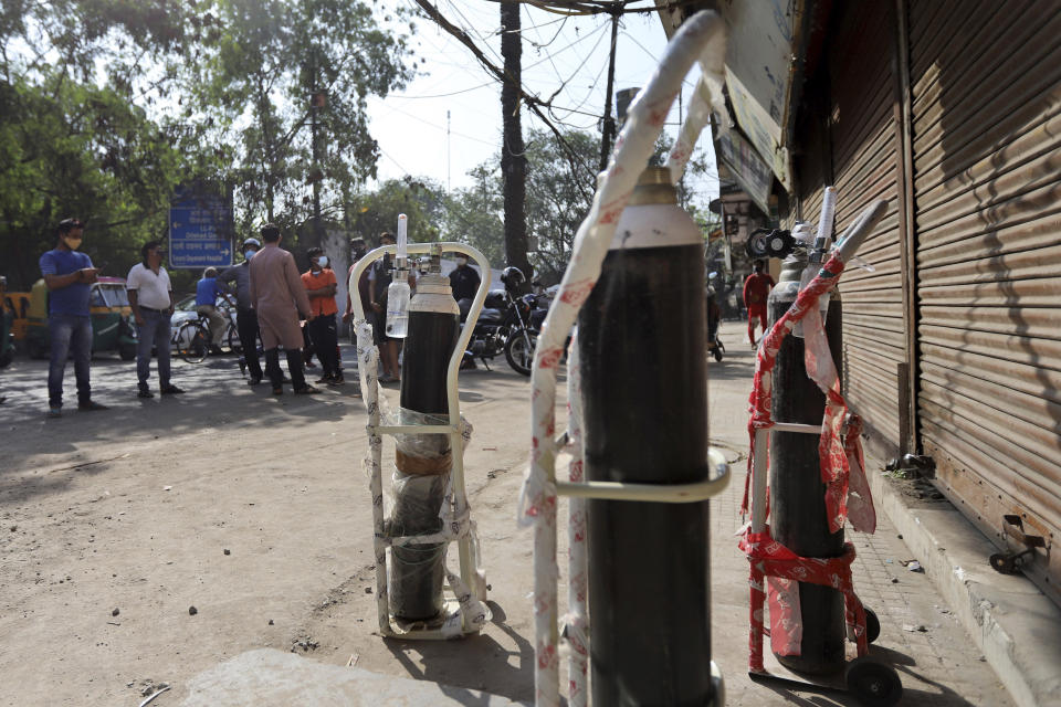 Relatives of COVID-19 patients wait for refill of their oxygen cylinders in New Delhi, India, Wednesday, April 21, 2021. India reported a global record of more than 314,000 new infections Thursday as a grim coronavirus surge in the world's second-most populous country sends more and more sick people into a fragile health care system critically short of hospital beds and oxygen. (AP Photo)