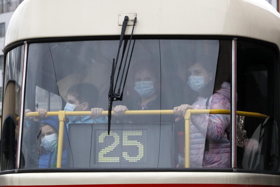 People riding on a tram wear face masks on a first school day in Prague, Czech Republic, Tuesday, Sept. 1, 2020. Starting Tuesday it is mandatory that all people must cover their mouths and noses in all of public transport and some public places in affords to stem the spread of COVID-19. (AP Photo/Petr David Josek)