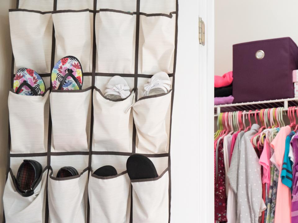 A young girl's closet neatly organized with hanging shoe rack, bins, and boxes