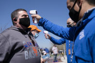 Fans arrive for COVID-19 screenings before entering Citifield before New York Mets home opening baseball game against the Miami Marlins, Thursday, April 8, 2021, in New York. (AP Photo/John Minchillo)