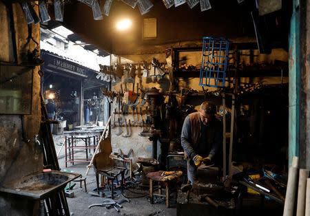 A man works in his shop in a narrow back alley of Sur, an historical district of southeastern province of Diyarbakir, Turkey, March 10, 2017. Picture taken March 10, 2017. REUTERS/Umit Bektas