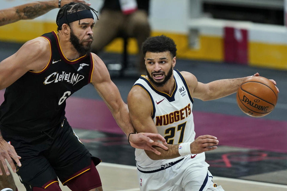 Denver Nuggets' Jamal Murray (27) drives past Cleveland Cavaliers' JaVale McGee (6) during the second half of an NBA basketball game Friday, Feb. 19, 2021, in Cleveland. (AP Photo/Tony Dejak)