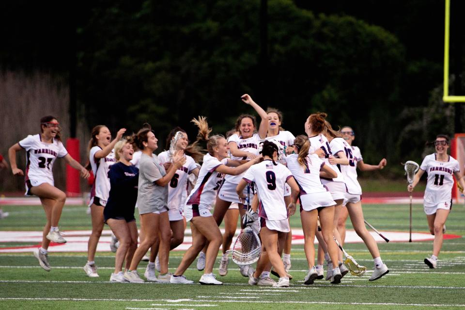 Members of the Lincoln-Sudbury varsity girls lacrosse team celebrate after defeating Reading, 7-3, in their Division 1 final four playoff game in Burlington, June 13, 2023. 