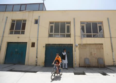 An Afghan boy rides his bicycle in front of a house, where a German aid worker and an Afghan guard were killed last night, in Kabul, Afghanistan May, 2017. REUTERS/Omar Sobhani